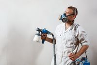 worker-painting-wall-with-spray-gun-white-color